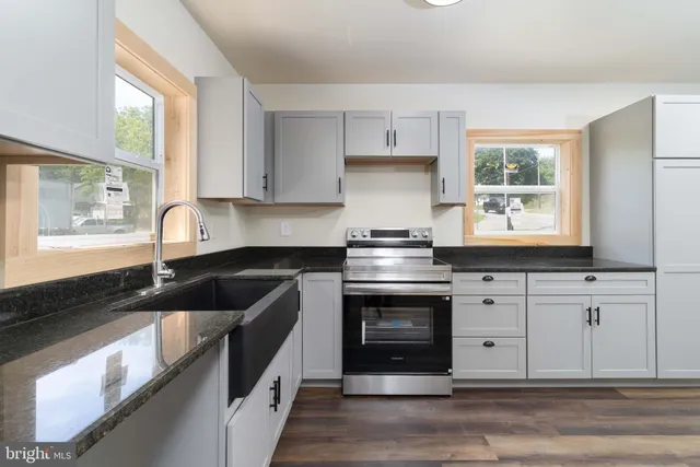a kitchen with granite countertop a sink and a stove