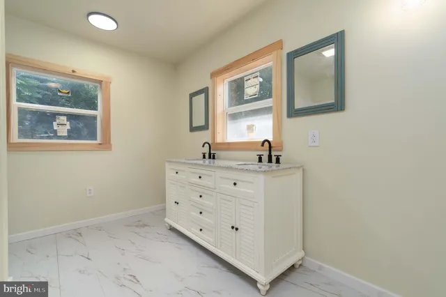 a bathroom with a double vanity sink and a mirror