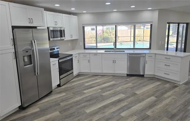 a kitchen with stainless steel appliances a refrigerator sink and cabinets