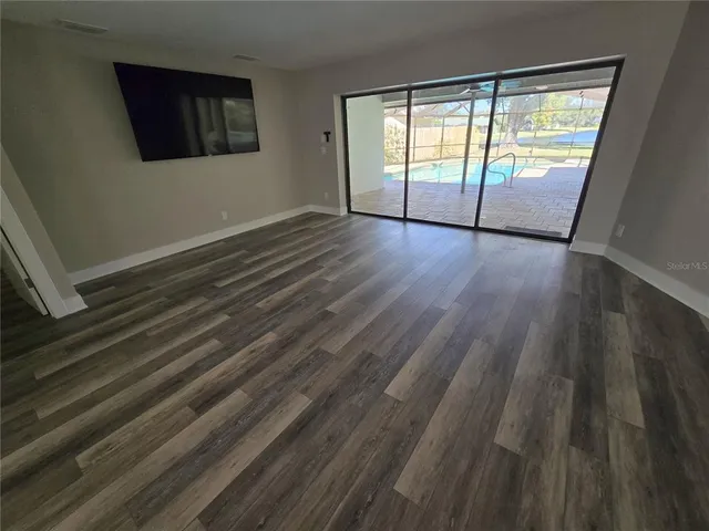 a view of a livingroom with wooden floor and stairs