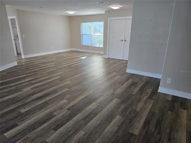 a view of a room with wooden floor and windows