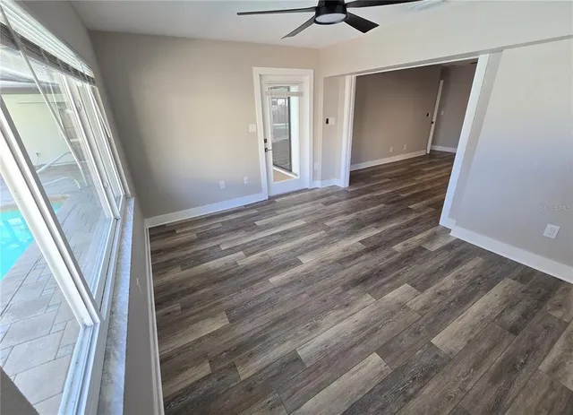 en empty room with wooden floor fan and window