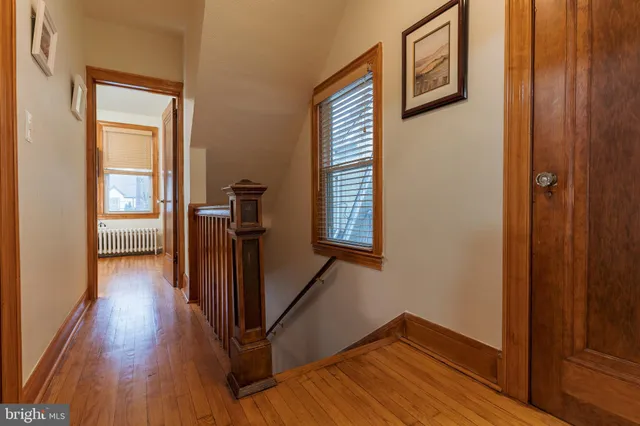 a view of a hallway with wooden floor and stairs