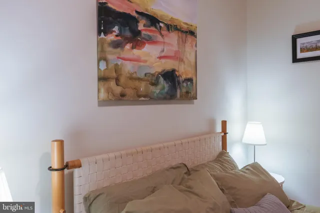 a bedroom with a bed and a painting on the wall