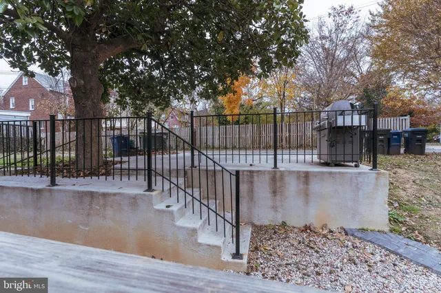 a view of a roof deck with wooden fence and large trees