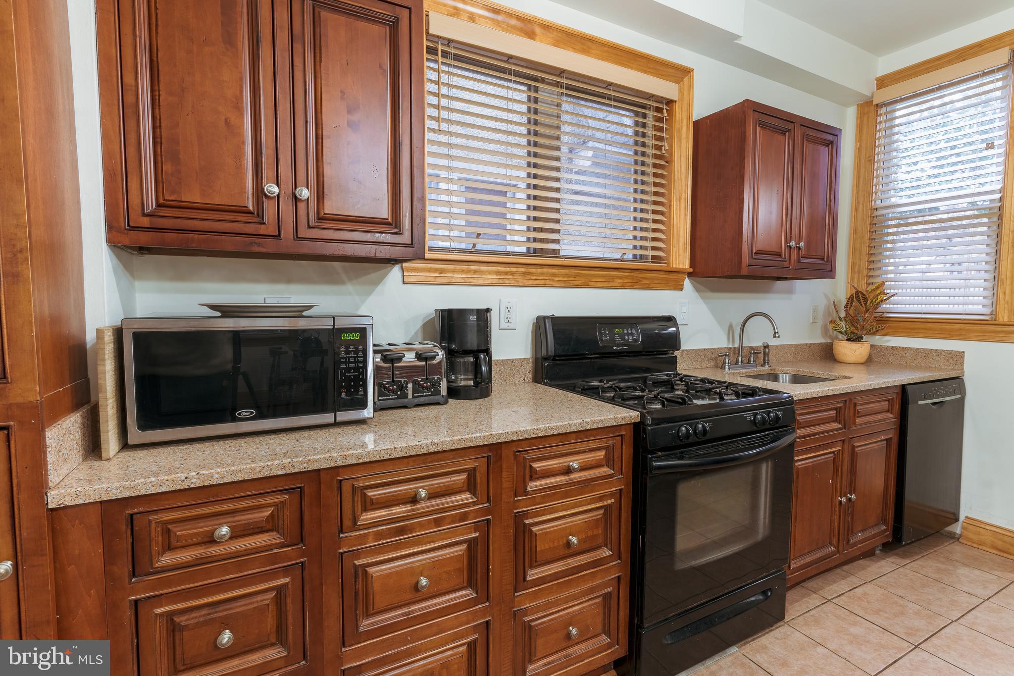 3817 22nd Street Northeast Washington, DC 20018 - Photo 8 of 37 a kitchen with stainless steel appliances granite countertop a stove microwave and cabinets