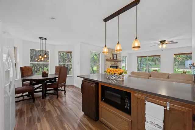 a kitchen with stainless steel appliances wooden floor dining table and chairs