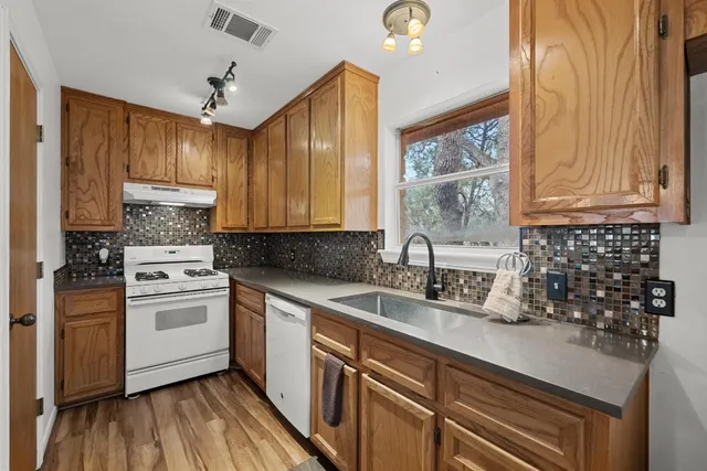 a kitchen with a sink window and cabinets