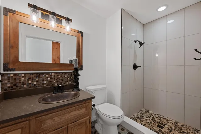 a bathroom with a toilet a sink and mirror