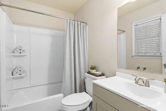 a bathroom with a sink a toilet and shower curtain