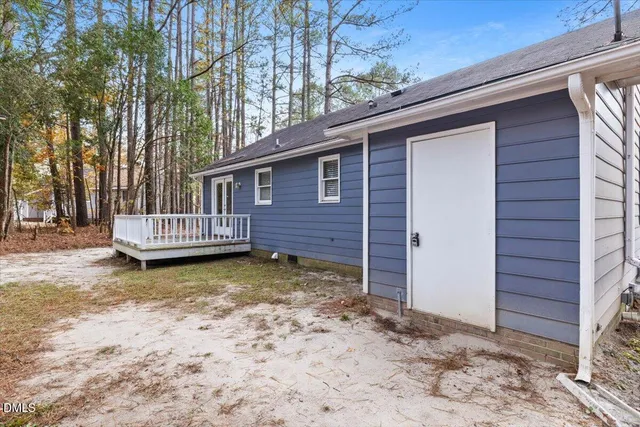 a view of a house with a wooden fence in a backyard