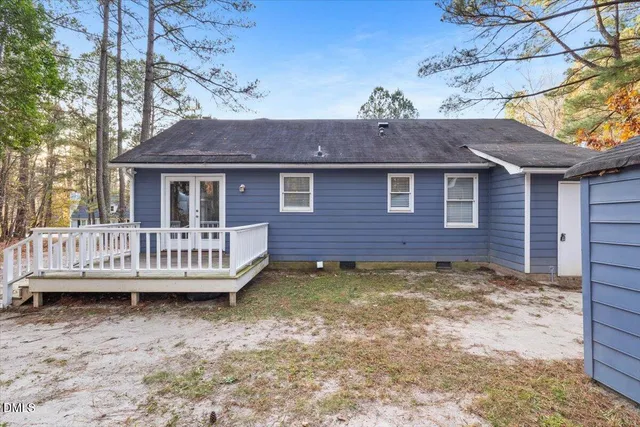 a view of a house with a wooden deck and a yard
