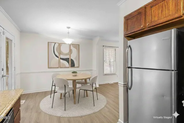 a kitchen with stainless steel appliances granite countertop a refrigerator a stove a microwave oven with white cabinets and wooden floor