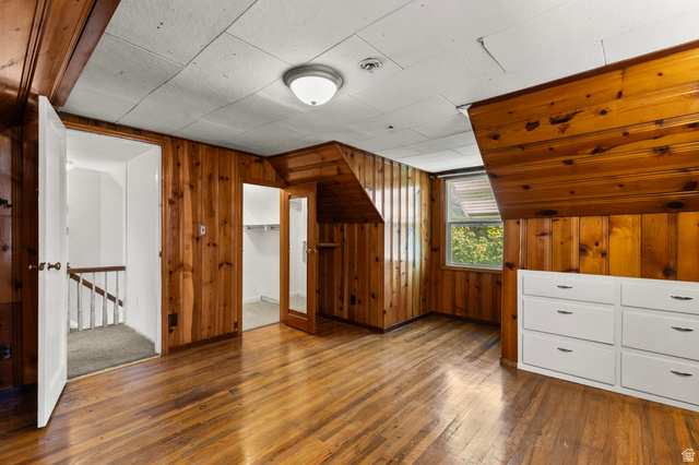 658 North 100 East Logan, UT 84321 - Photo 14 of 26 Wood-paneled room featuring wood-finish flooring, a window providing natural light, a built-in white dresser with six drawers, and a ceiling-mounted light fixture