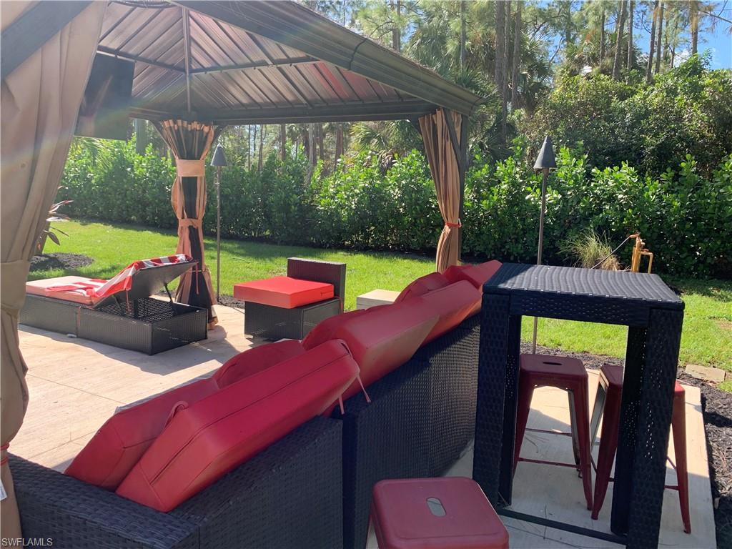 3651 29th Avenue Southwest Naples, FL 34117 - Photo 14 of 49 a view of a patio with a table chairs and a backyard