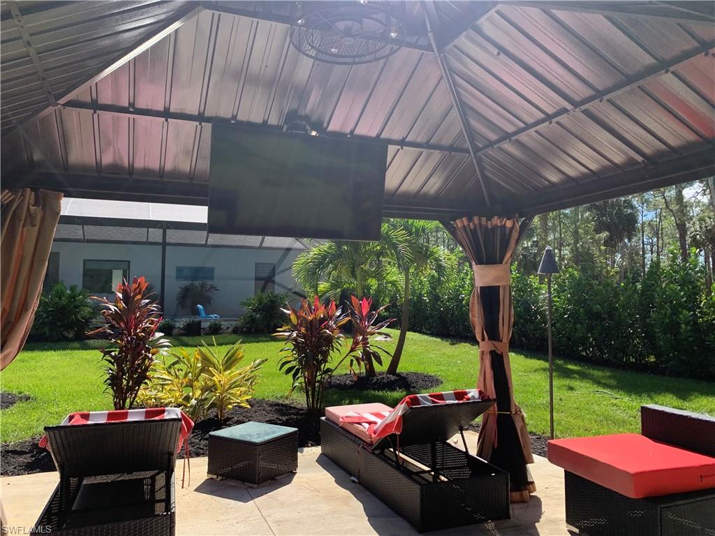 3651 29th Avenue Southwest Naples, FL 34117 - Photo 15 of 49 a view of a patio with table and chairs potted plants with a backyard