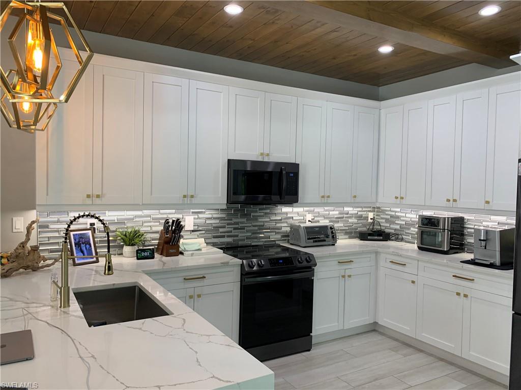 3651 29th Avenue Southwest Naples, FL 34117 - Photo 21 of 49 a kitchen with white cabinets and appliances