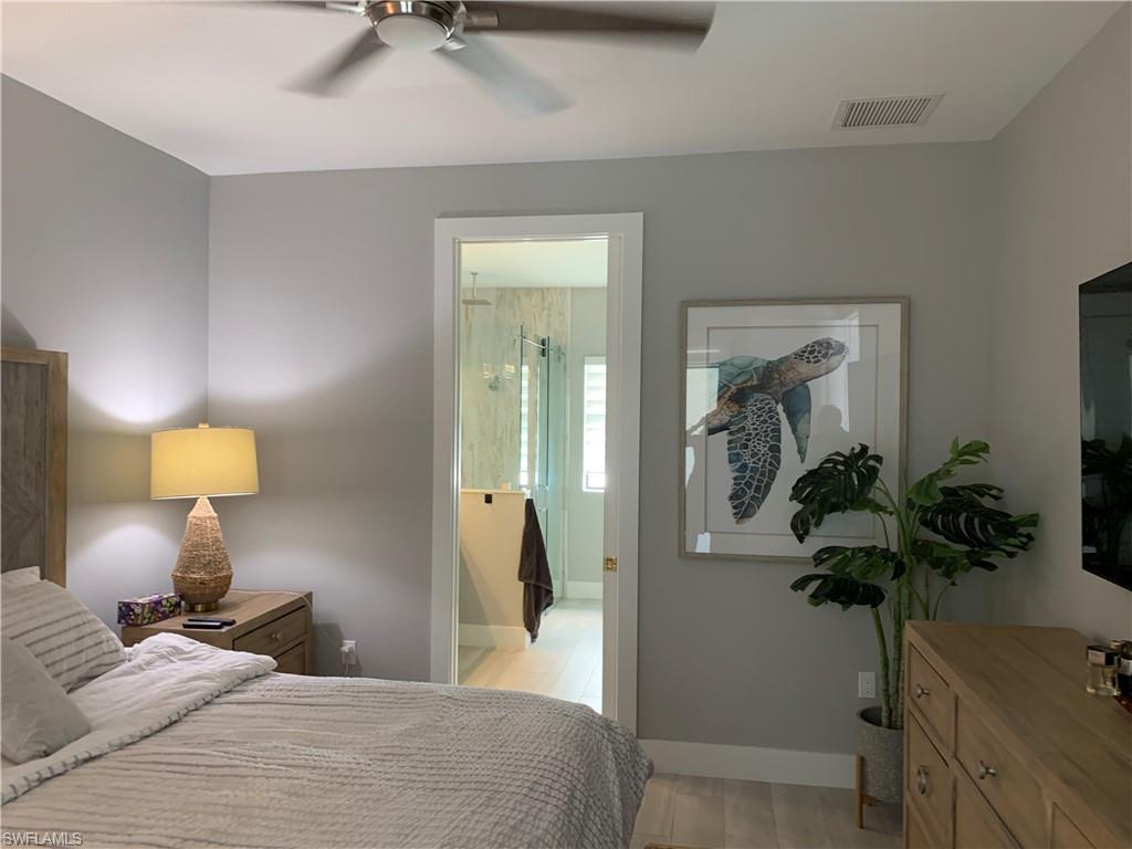 3651 29th Avenue Southwest Naples, FL 34117 - Photo 24 of 49 a bedroom with a bed and a potted plant