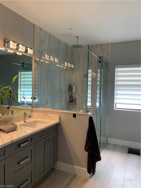 3651 29th Avenue Southwest Naples, FL 34117 - Photo 28 of 49 a spacious bathroom with a double vanity sink a mirror and a bathtub
