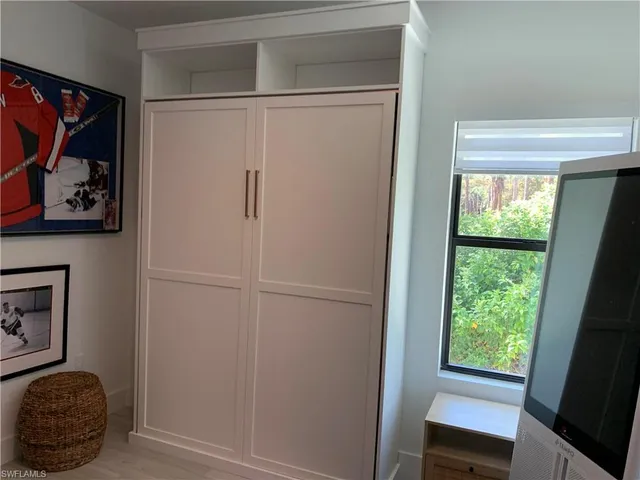 a room with a window and a painting on the wall