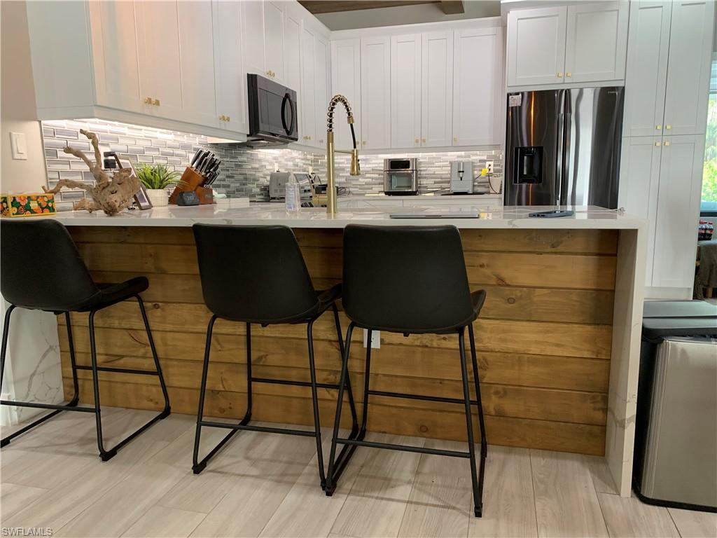3651 29th Avenue Southwest Naples, FL 34117 - Photo 41 of 49 a kitchen with stainless steel appliances granite countertop a sink and a refrigerator