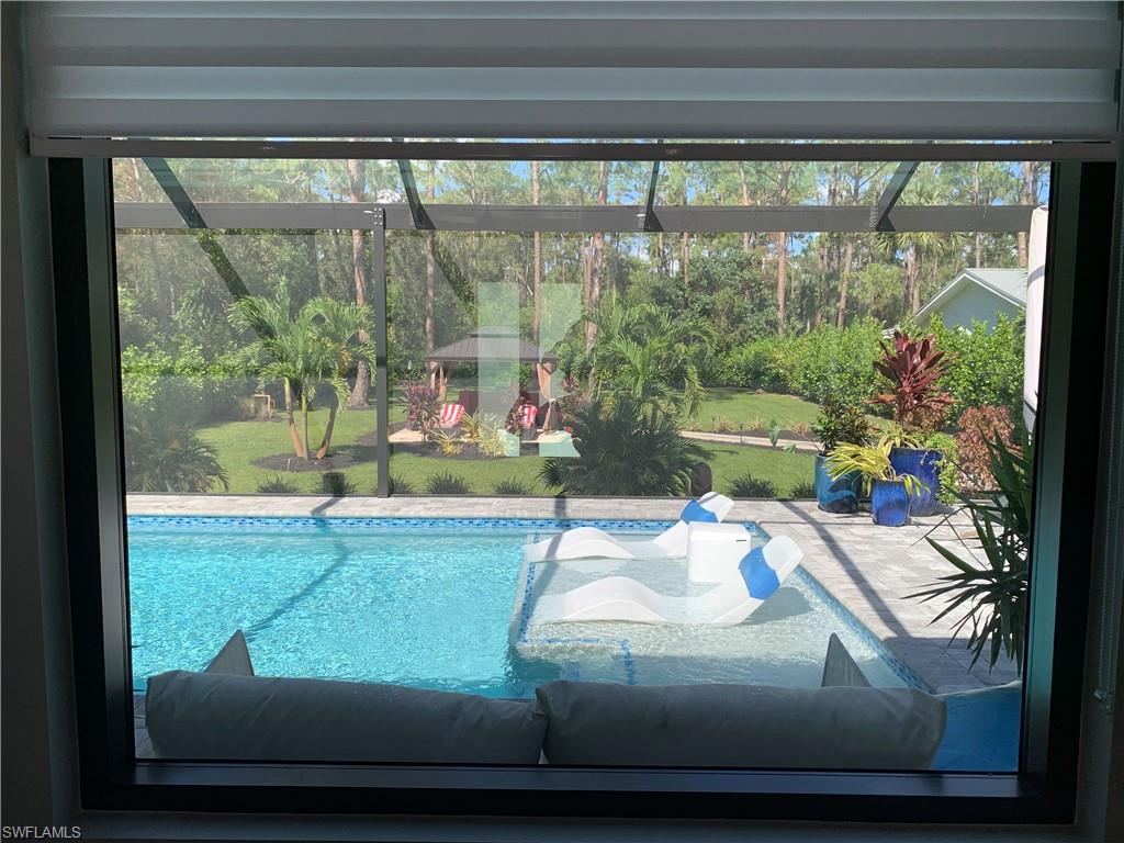 3651 29th Avenue Southwest Naples, FL 34117 - Photo 10 of 49 a room with a floor to ceiling window and a potted plant