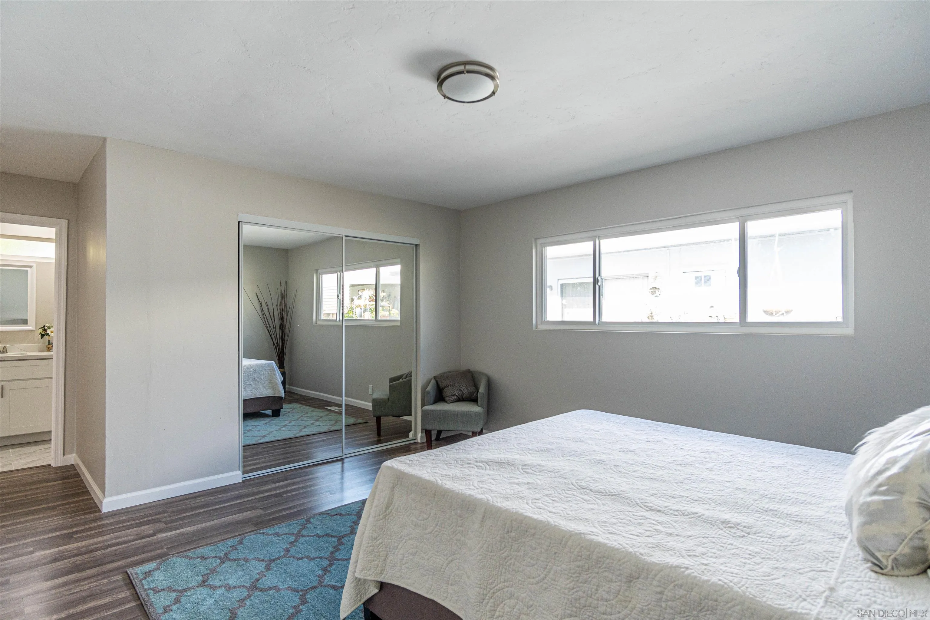 3747 Vista Campana South, Unit 43 Oceanside, CA 92057 - Photo 15 of 30 a bedroom with a bed and wooden floor