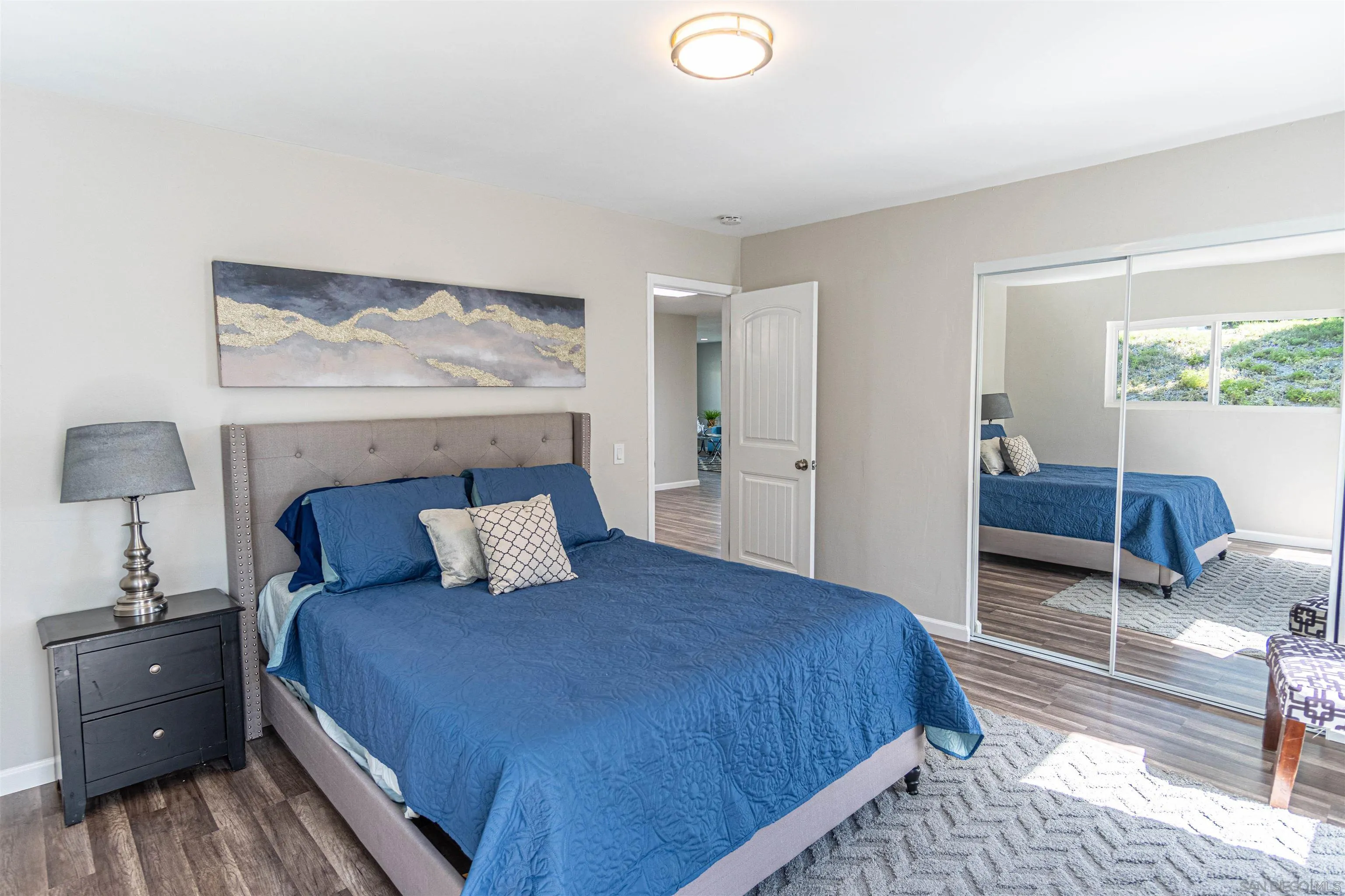 3747 Vista Campana South, Unit 43 Oceanside, CA 92057 - Photo 18 of 30 a bedroom with a bed and wooden floor