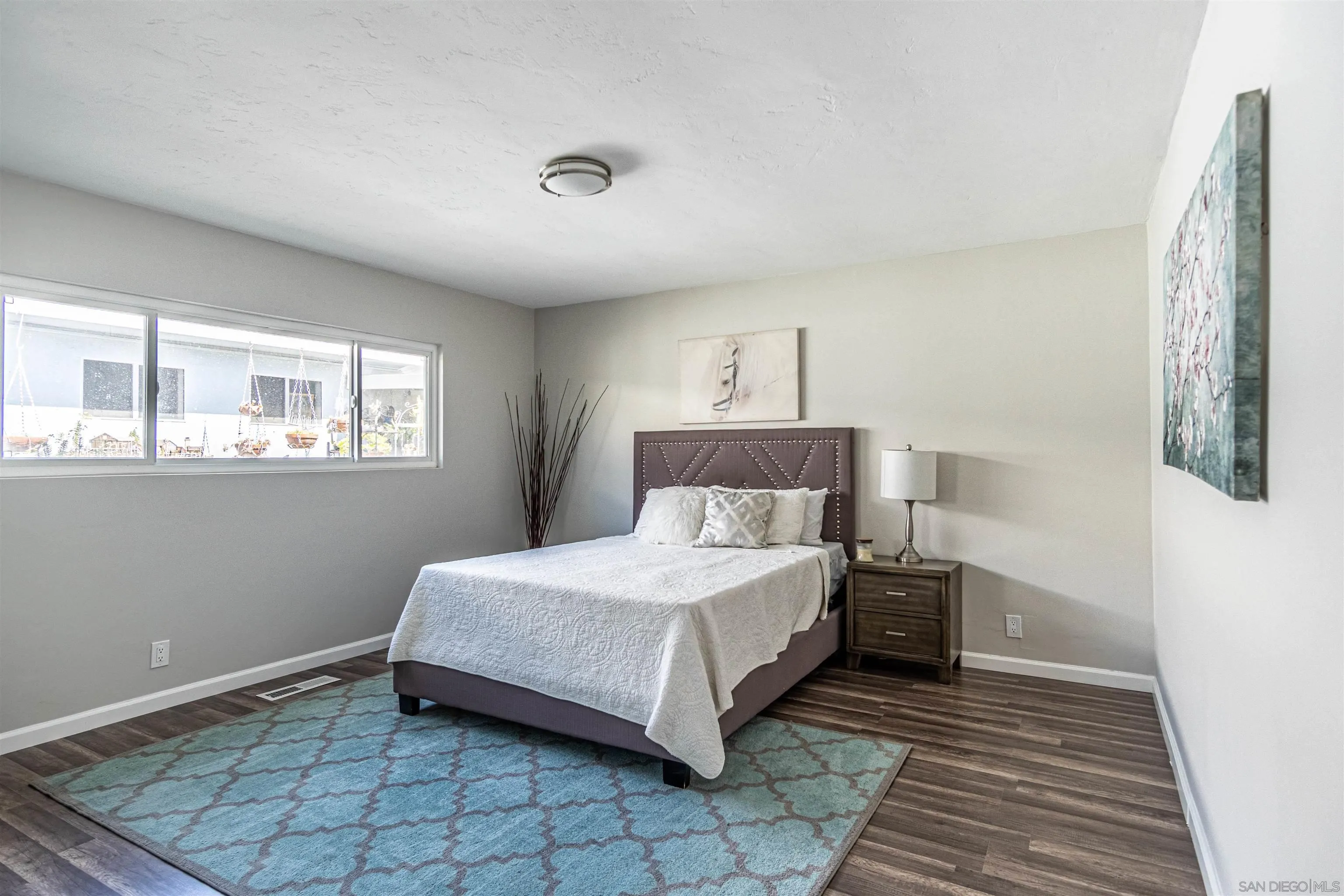 3747 Vista Campana South, Unit 43 Oceanside, CA 92057 - Photo 5 of 30 a bedroom with a bed lamp and window