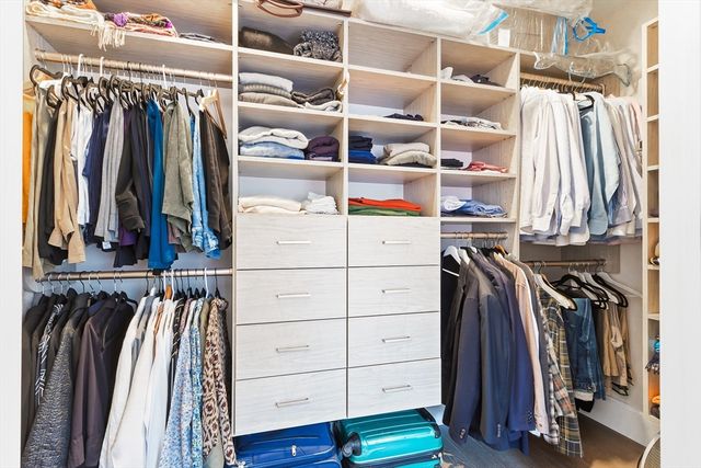a view of walk in closet with clothes