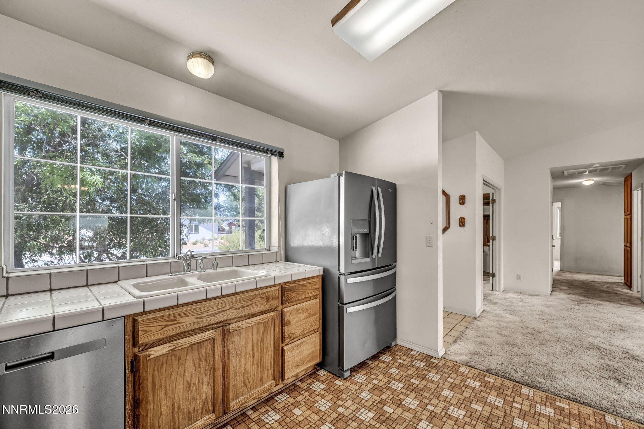 692 Lassen Way Gardnerville, NV 89460 - Photo 13 of 34 a kitchen with stainless steel appliances granite countertop a refrigerator and a sink