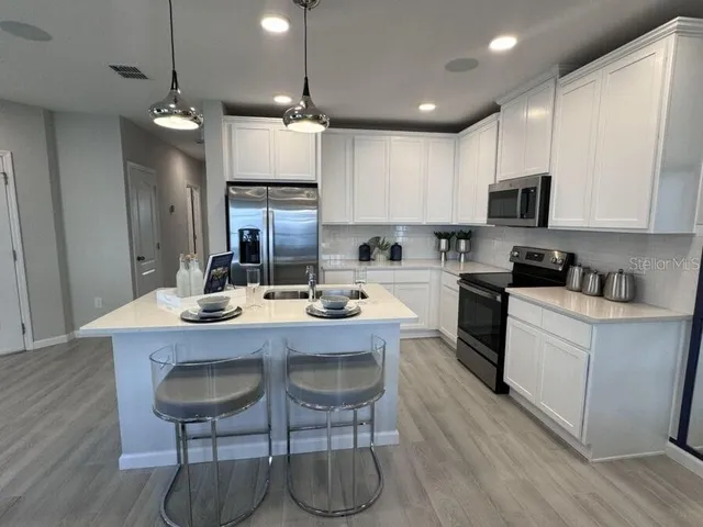 a kitchen with a sink cabinets and wooden floor