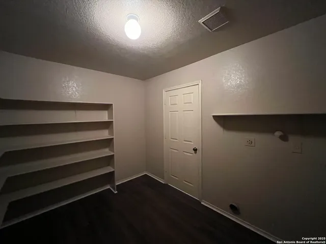 a view of storage and utility room with wooden floor