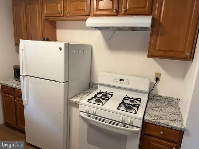 a white refrigerator freezer and a stove sitting inside of a kitchen