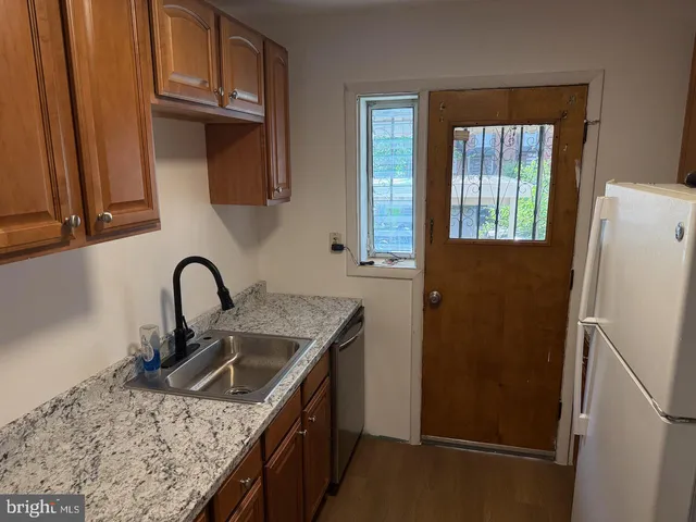 a kitchen with a sink a refrigerator and cabinets