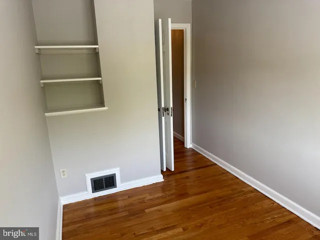a view of an empty room with wooden floor