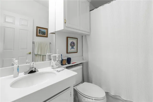 a bathroom with a sink a toilet and mirror