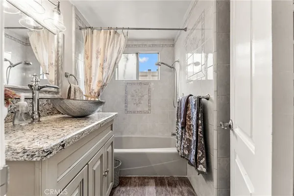 a bathroom with a granite countertop sink a toilet and shower