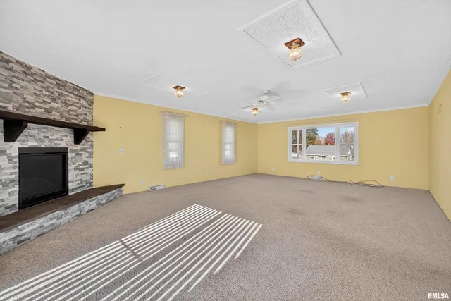 a view of an empty room with a fireplace and a window