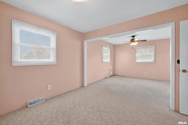 an empty room with windows and closet