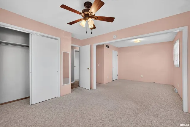 a view of an empty room and a ceiling fan
