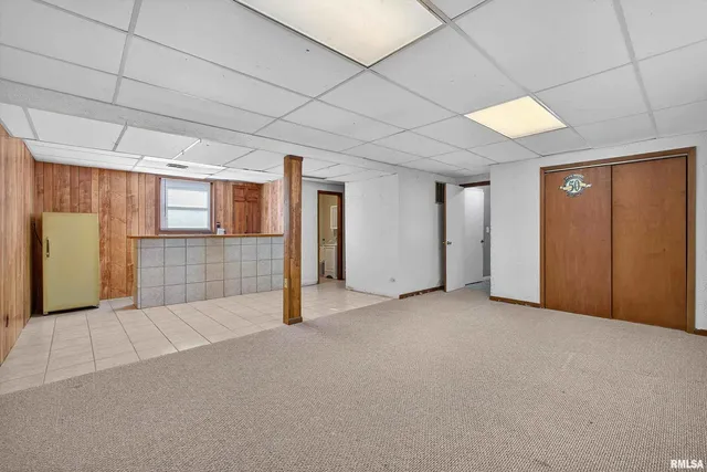 a view of an empty room with closet and a window