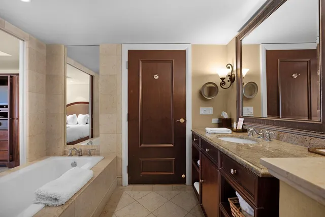 a spacious bathroom with a bathtub sink and mirror