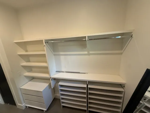 a view of walk in closet with empty racks