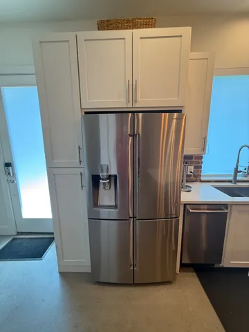 a metallic refrigerator freezer sitting in a kitchen