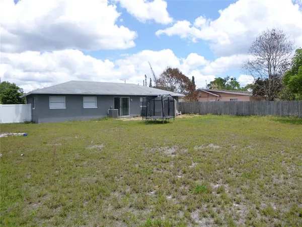a view of a house with a yard and a large tree