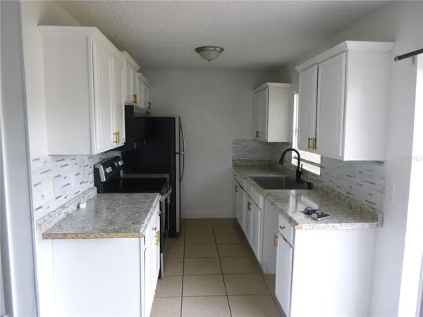 a kitchen with granite countertop a sink and a stove top oven