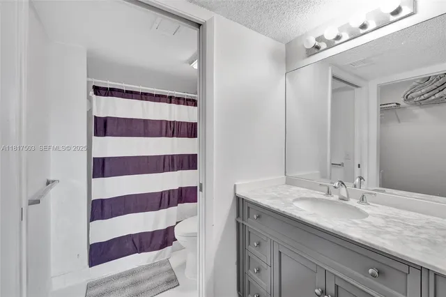 a bathroom with a sink a mirror a vanity and a shower