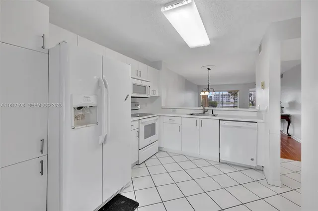 a kitchen with white cabinets and white appliances