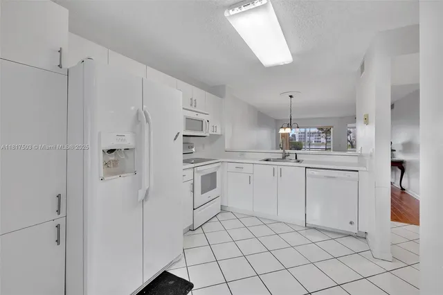 a kitchen with white cabinets and white appliances